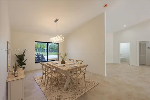 a room with a table chairs and a kitchen view