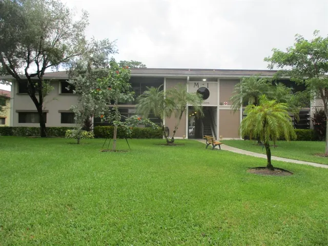 a view of a house with backyard and a tree