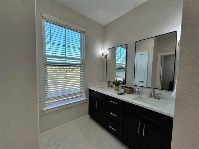 a bathroom with a double vanity sink and mirror