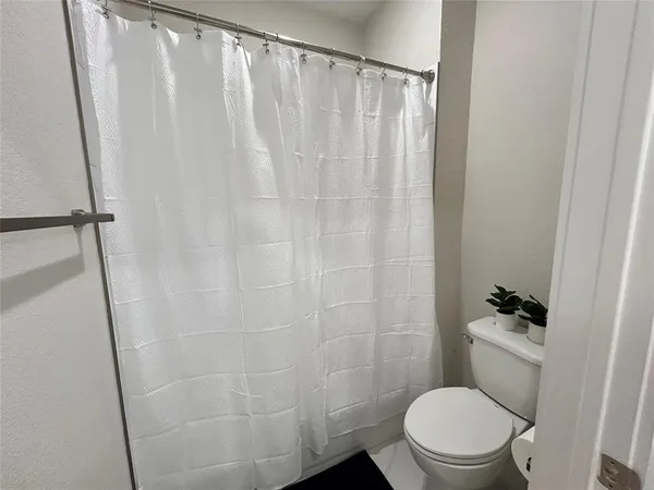 a white toilet sitting next to a shower curtain