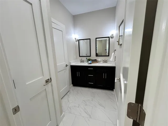 a spacious bathroom with a double vanity sink and mirror