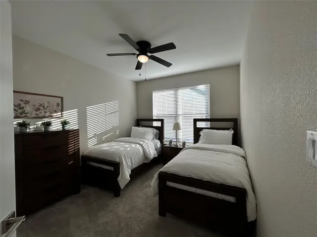 a bedroom with two beds and window