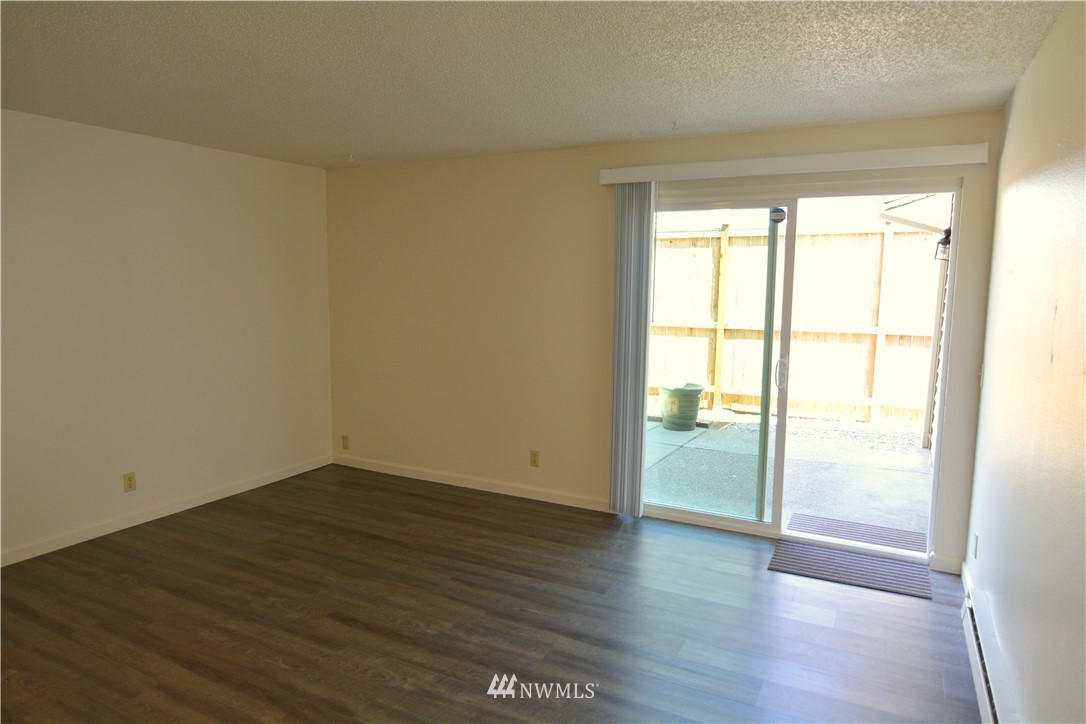 20515 Filbert Drive Bothell, WA 98012 - Photo 3 of 20 a view of an empty room with wooden floor and a window
