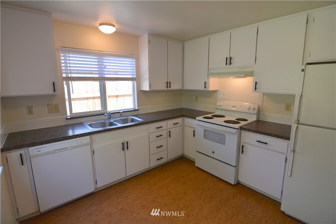 20515 Filbert Drive Bothell, WA 98012 - Photo 6 of 20 a kitchen with granite countertop white cabinets and white appliances