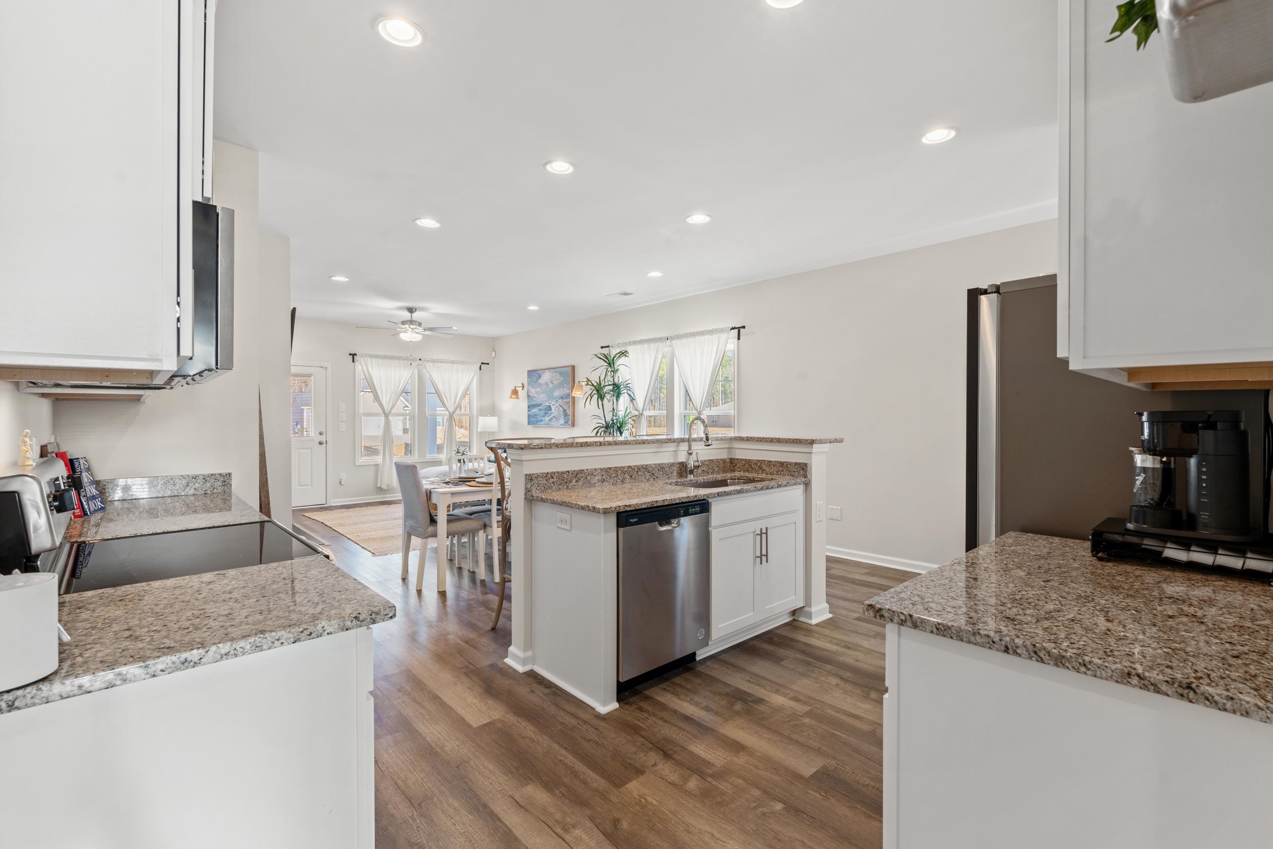 361 Palmetto Sand Loop Conway, SC 29527 - Photo 12 of 28 Kitchen with recessed lighting, stainless steel appliances, white cabinets, light stone counters, and a center island with sink