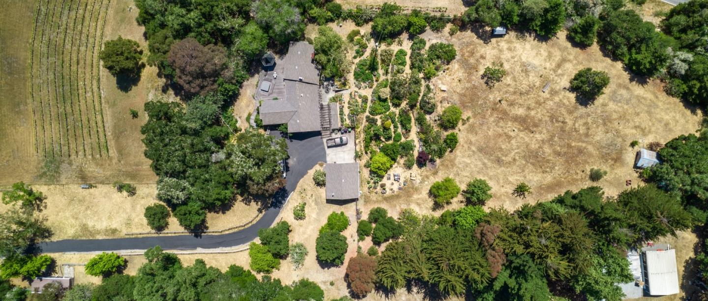 an aerial view of residential house with outdoor space and trees all around