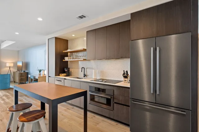 a kitchen with stainless steel appliances granite countertop a sink and a refrigerator