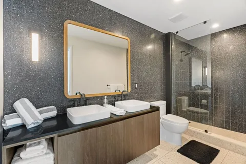 a bathroom with a double vanity sink a toilet and a mirror