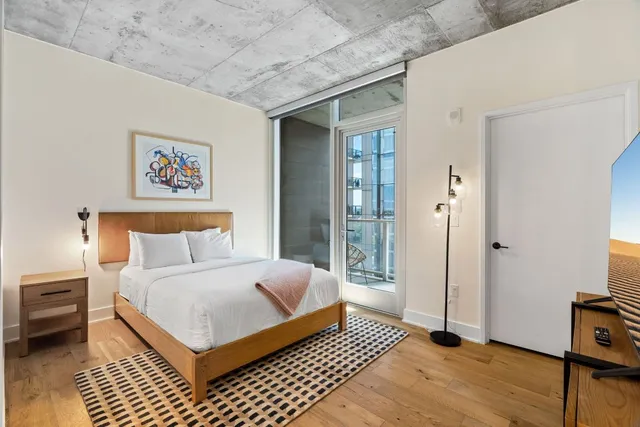 a bedroom with a bed and a large window