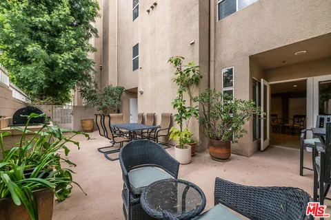 a view of a patio with plants and chairs