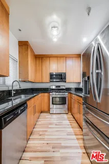 a kitchen with stainless steel appliances granite countertop a refrigerator and a sink