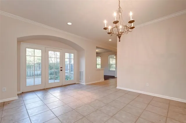 a view of a livingroom with a chandelier fan and windows