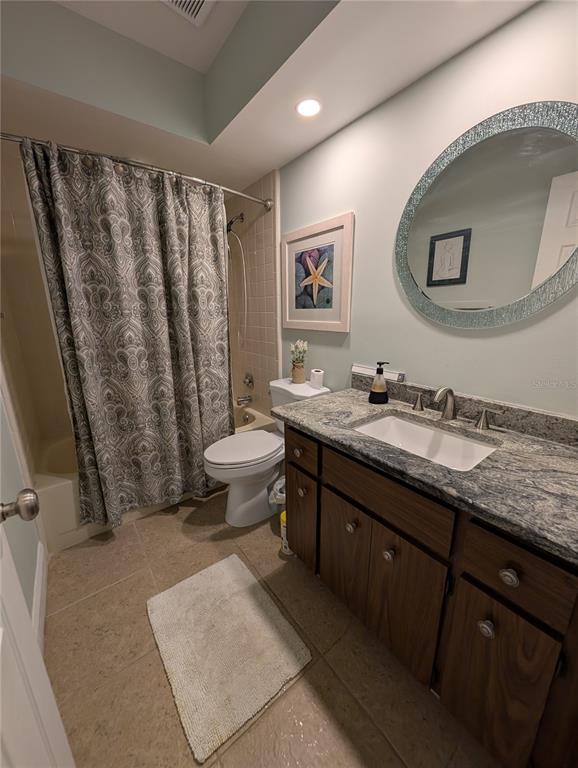 8161 Braddock Circle, Unit 1 Port Richey, FL 34668 - Photo 18 of 27 a bathroom with a granite countertop sink mirror vanity and toilet