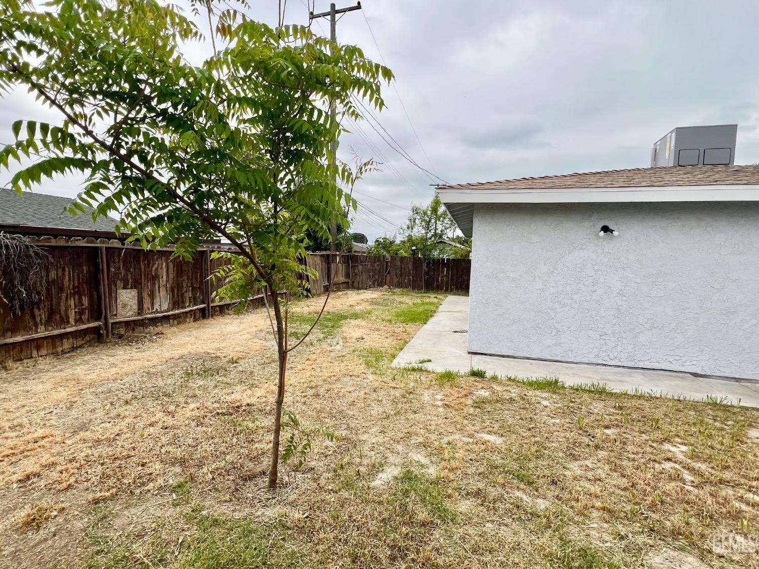 Undisclosed Address Bakersfield, CA 93307 - Photo 21 of 24 a front view of a house with a yard