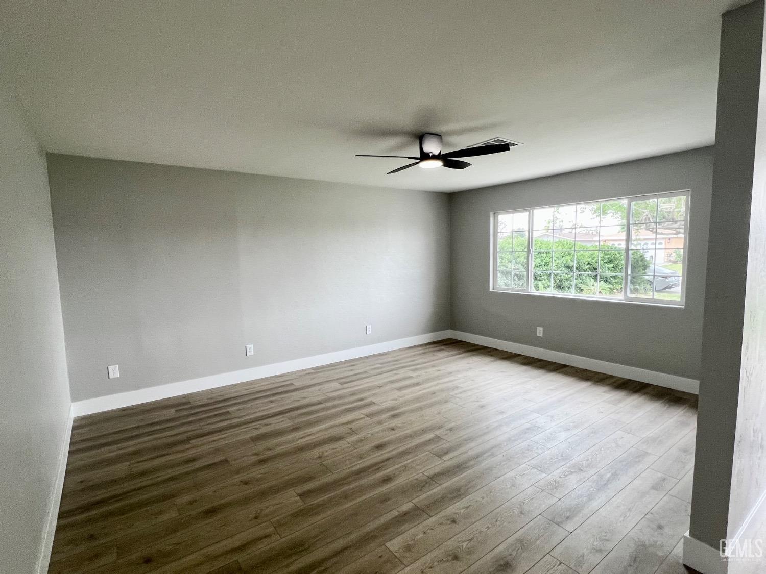 Undisclosed Address Bakersfield, CA 93307 - Photo 4 of 24 wooden floor in an empty room with a window