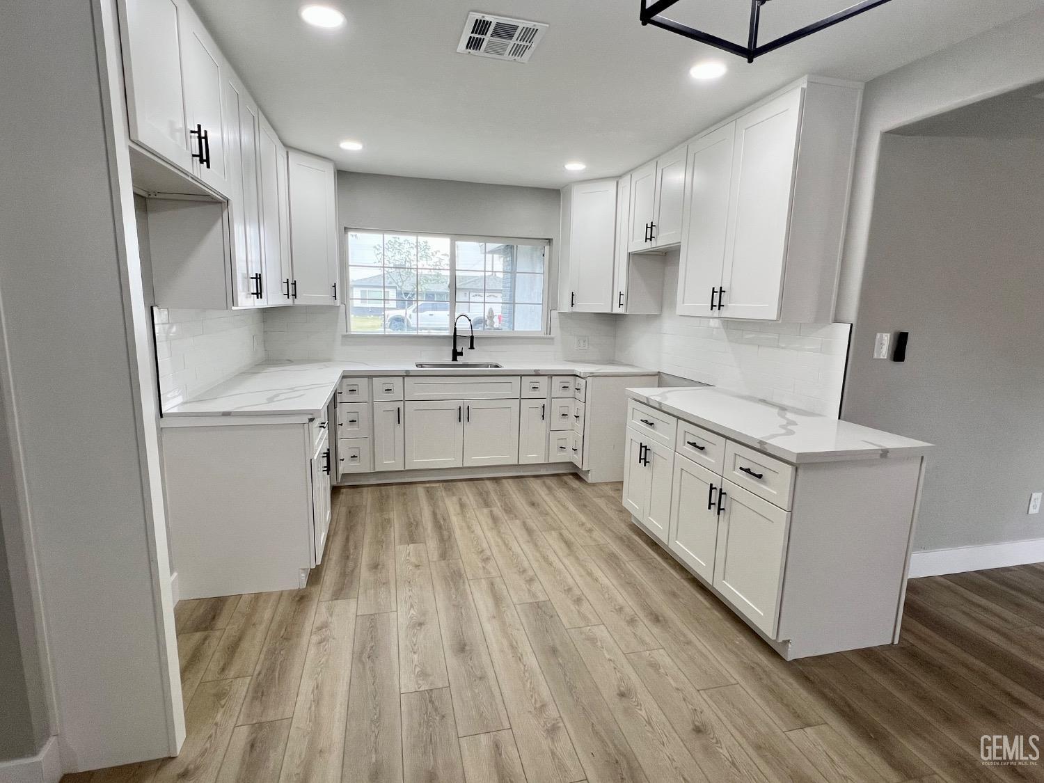 Undisclosed Address Bakersfield, CA 93307 - Photo 5 of 24 a kitchen with white cabinets appliances and a sink