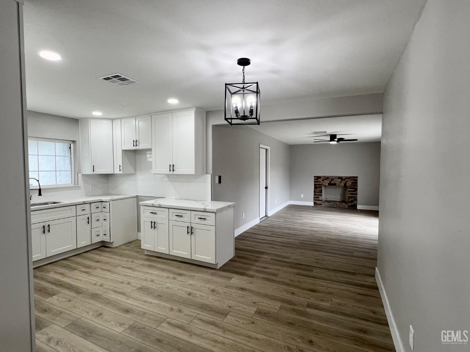 Undisclosed Address Bakersfield, CA 93307 - Photo 9 of 24 a kitchen with granite countertop a stove cabinets and wooden floor