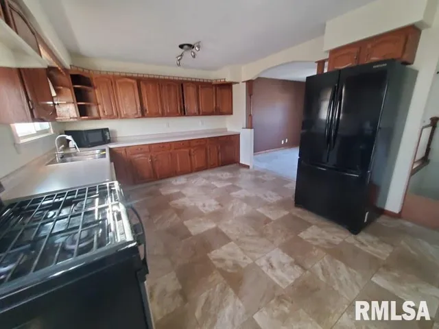 a kitchen with stainless steel appliances granite countertop a refrigerator and a stove