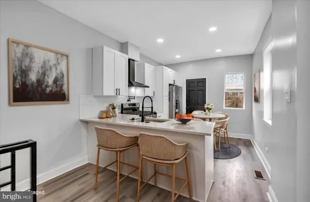 a kitchen with stainless steel appliances a table and chairs in it