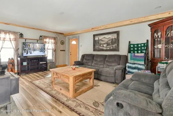 a living room with furniture a flat screen tv and a wall clock