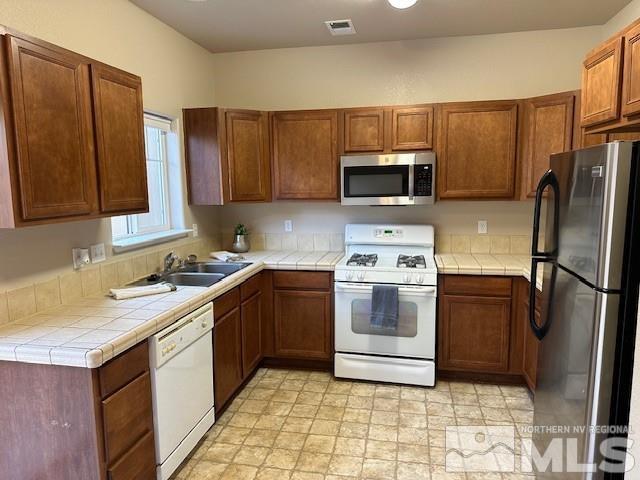 4628 Kathleen Denise Lane Reno, NV 89503 - Photo 2 of 13 a kitchen with a sink stove and refrigerator