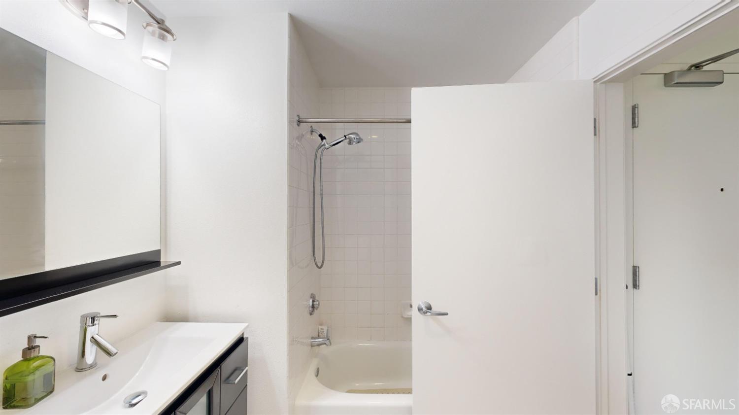 888 7th Street, Unit 234 San Francisco, CA 94107 - Photo 9 of 10 a bathroom with a granite countertop sink mirror and shower