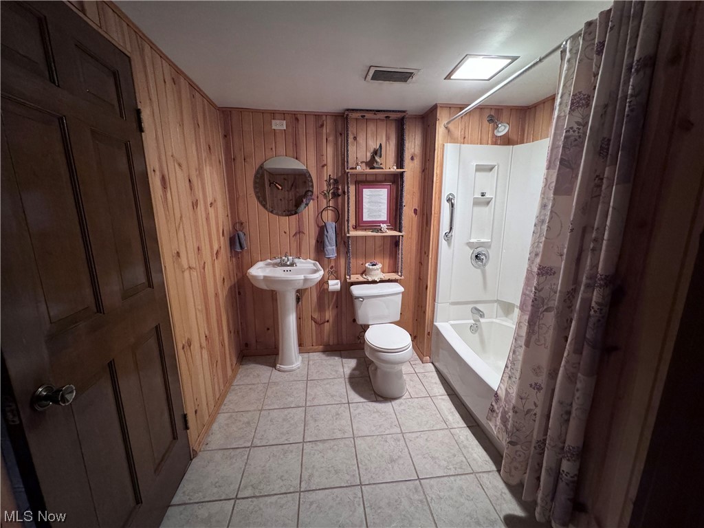 2361 Dutch Ridge Road Parkersburg, WV 26104 - Photo 16 of 17 Full bathroom with toilet, shower / bath combination with curtain, tile floors, and wood walls