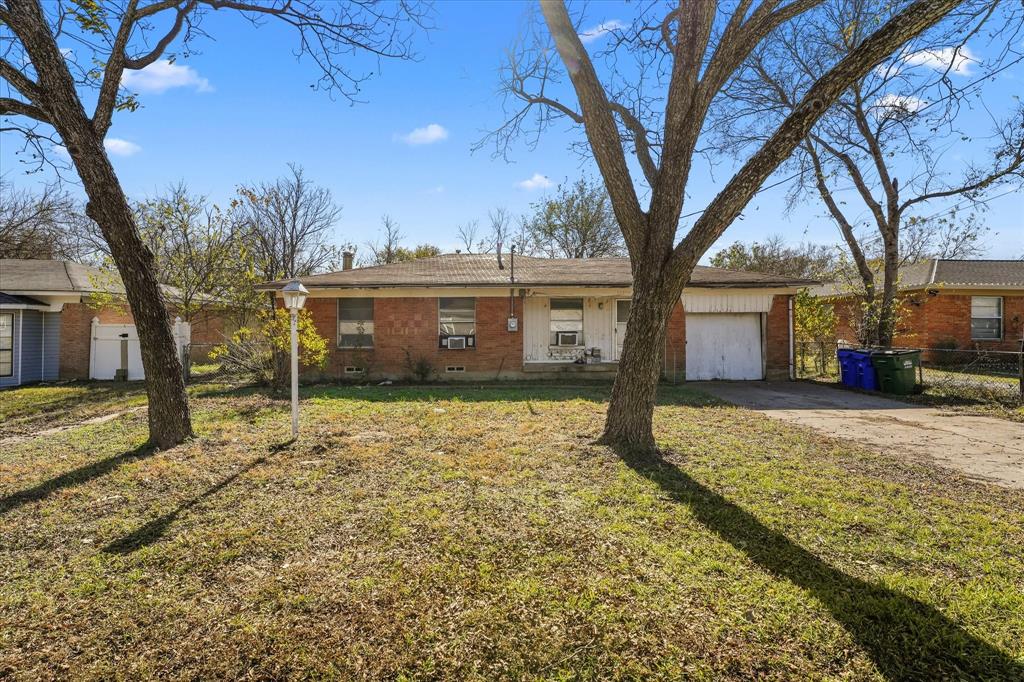 12924 Mitchell Drive Balch Springs, TX 75180 - Photo 1 of 14 a view of a house with a large tree and a yard