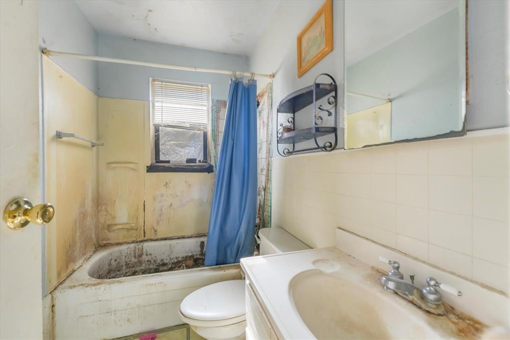 12924 Mitchell Drive Balch Springs, TX 75180 - Photo 7 of 14 a bathroom with a sink toilet and shower