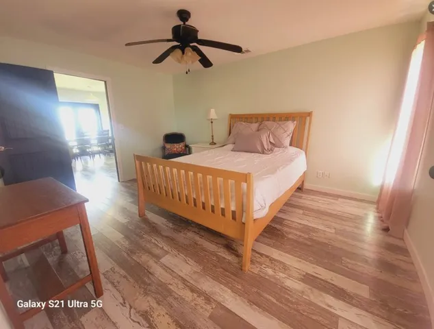 a bedroom with a bed and a mirror on the dresser