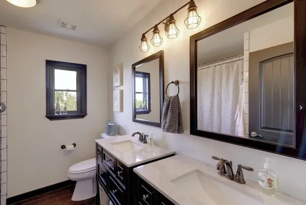 a bathroom with a granite countertop sink toilet and a mirror