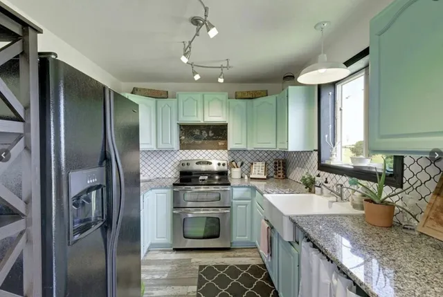 a kitchen with granite countertop a sink stainless steel appliances and counter space