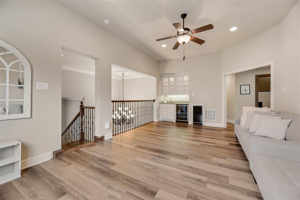 1909 Rising Star Drive Allen, TX 75013 - Photo 13 of 26 Unfurnished living room featuring ceiling fan, light wood finished floors, wine cooler, and suspended lighting