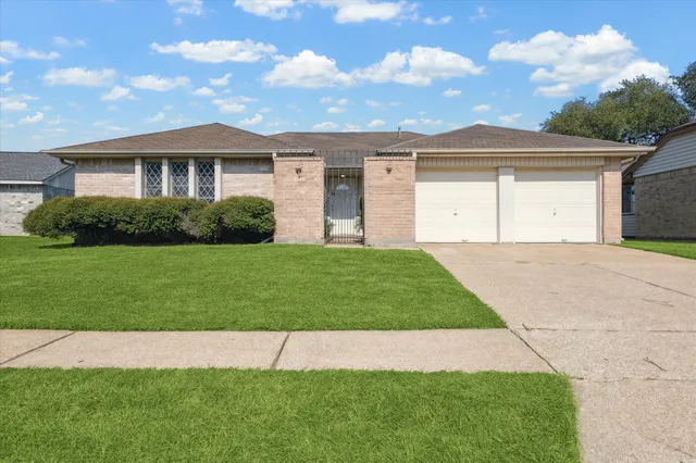 a front view of a house with a garden and yard