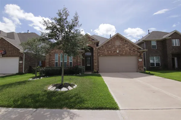 a backyard of a house with a garden and barbeque oven