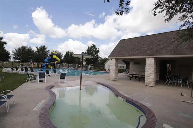 an outdoor space with swimming pool and furniture