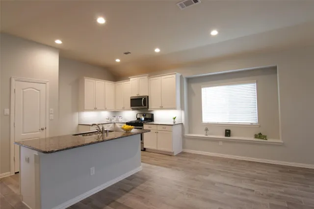 a kitchen with a sink cabinets and window