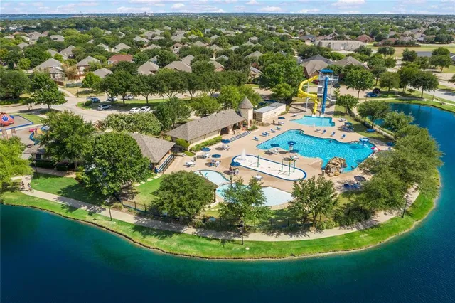 an aerial view of residential houses with outdoor space and trees