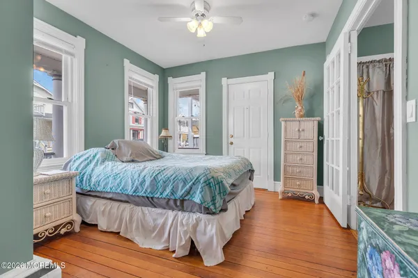 a bedroom with a bed wooden floor and window