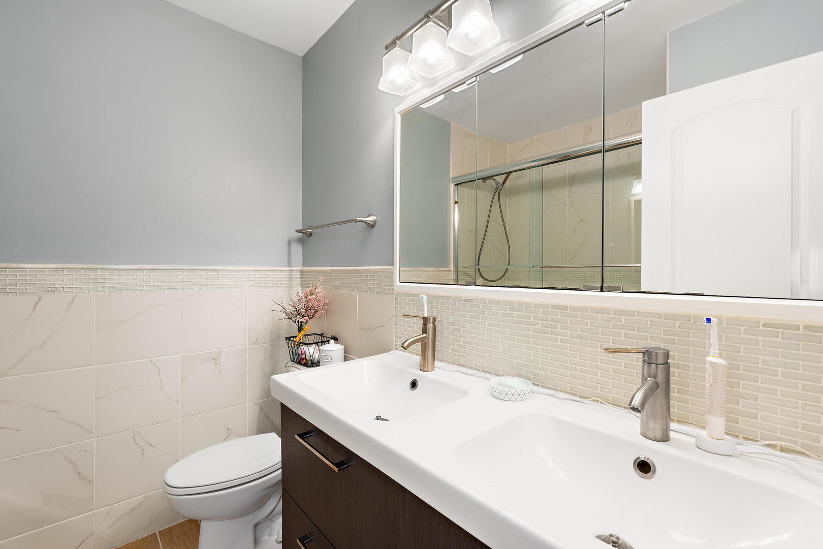 1527 Sunset Ridge Road Glenview, IL 60025 - Photo 13 of 20 a bathroom with a sink a toilet and a mirror