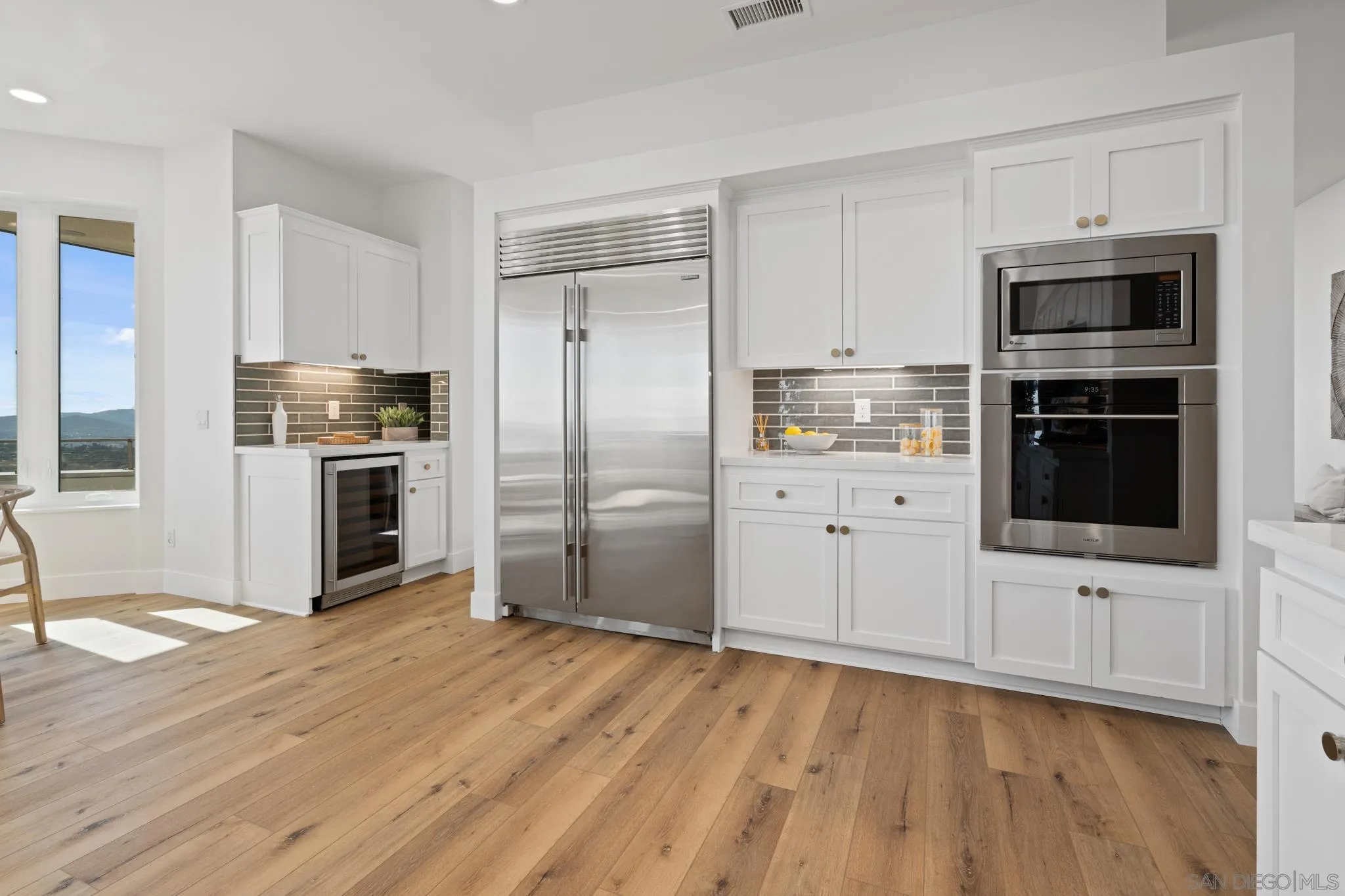 15486 Markar Road Poway, CA 92064 - Photo 17 of 63 a kitchen with white cabinets and stainless steel appliances