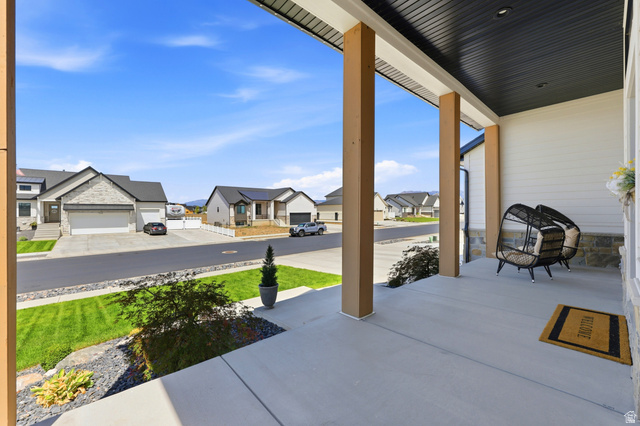 4331 West 475 South West Point, UT 84015 - Photo 2 of 46 Covered front porch with wood-tone support columns, white siding, and stone accents