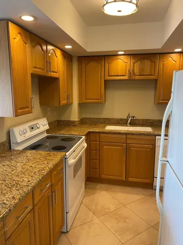 a kitchen with a sink a stove and cabinets