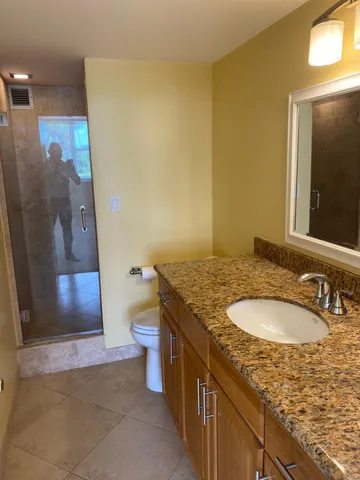 a bathroom with a granite countertop sink and a mirror