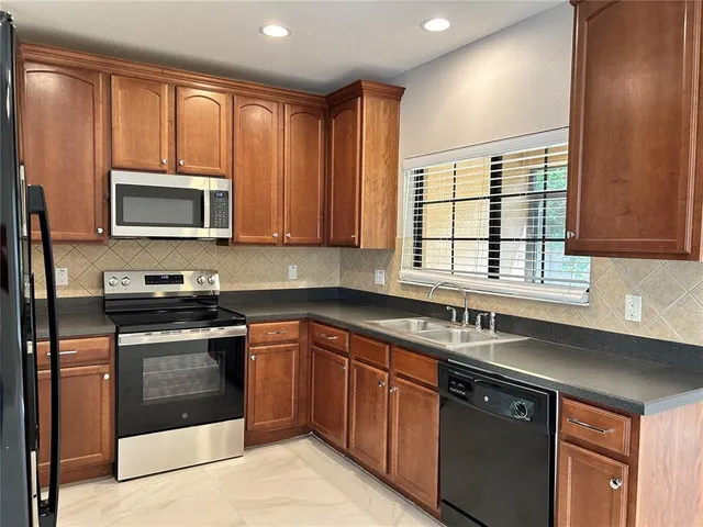 a kitchen with stainless steel appliances granite countertop a stove sink microwave and cabinets