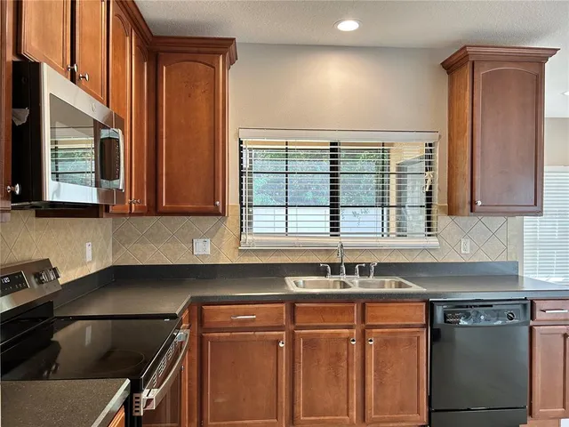 a kitchen with granite countertop a sink and a stove