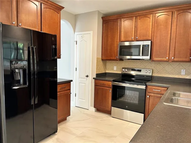 a kitchen with stainless steel appliances granite countertop a refrigerator stove and microwave
