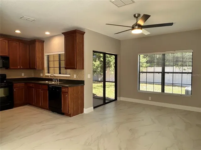 a large kitchen with kitchen island granite countertop a stove a sink and a refrigerator