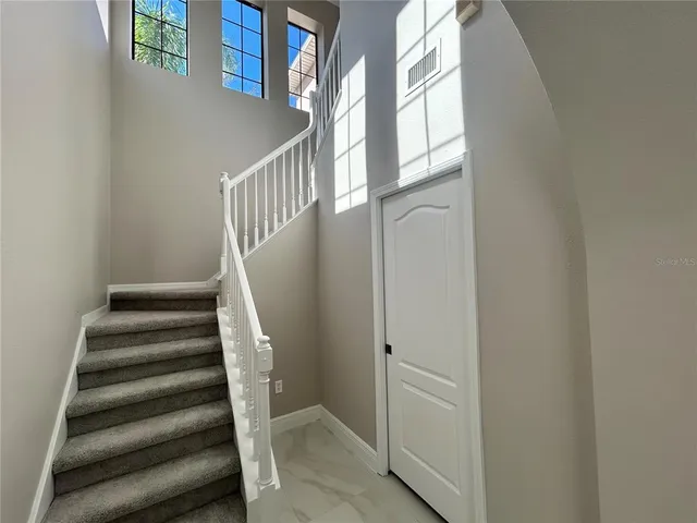 a view of staircase with lots of frames on wall and a window