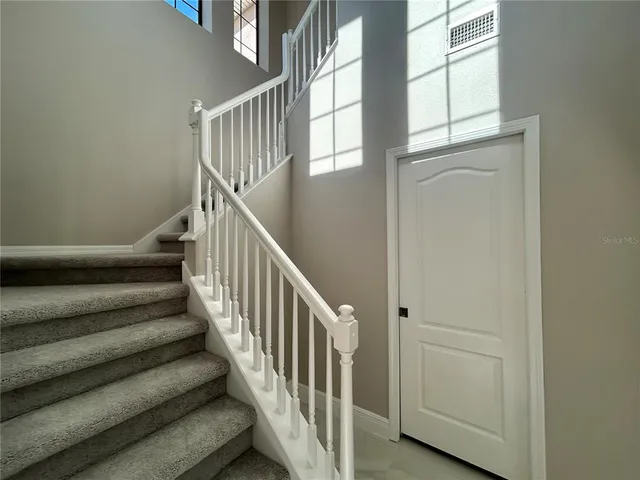 a view of staircase with lots of frames on wall and a window